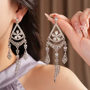 Close-up view of sparkling silver tassel earrings with intricate flower and diamond details