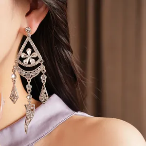 Detail of silver needle rhinestone floral tassel drop earrings on model's ear