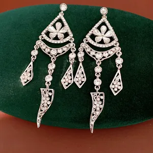 Close-up of elaborate silver rhinestone earrings with floral tassels and delicate patterns