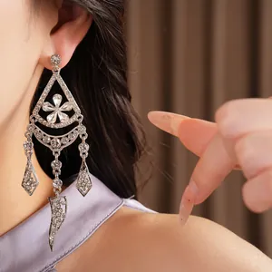 Close-up of elegant silver flower chandelier earrings with sparkling rhinestones on model