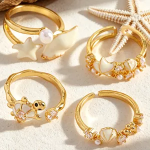 Detalle de anillos con temática playera y diseños de conchas, estrellas y tortugas
