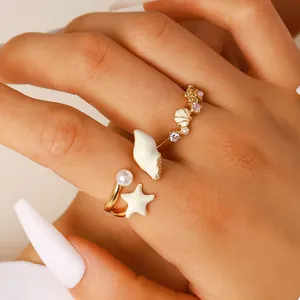 Primer plano de un anillo abierto de vacaciones con detalles de conchas y estrellas de mar