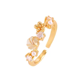 Primer plano de anillo playero dorado con diseño de concha estrella de mar y circón