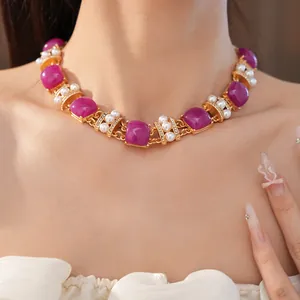 Detalle de collar vintage con piedras violetas cuadradas, perlas y pequeños cristales