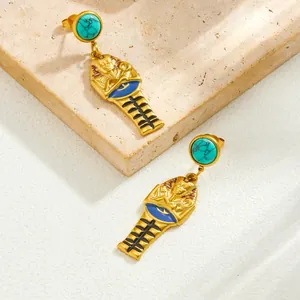 Dettaglio degli orecchini a forma di faraone egizio placcati in oro con pietre di turchese