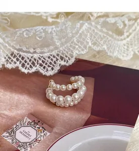 Λεπτομερής προβολή ενός ear cuff με πέρλες σε κομψό και minimal φόντο
