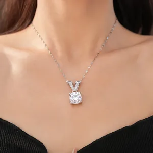Close-up of minimalist silver necklace with V-shaped zircon pendant on model