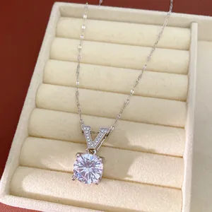 Detailed macro view of a silver V-shaped pendant necklace with round zircon in a jewelry box.