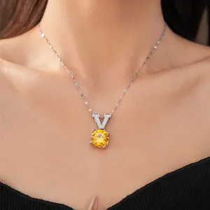 Detailed close-up of elegant V-shaped pendant necklace with a round yellow gemstone