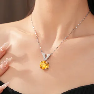Close-up of a silver V-letter necklace with a round yellow zircon pendant on neck