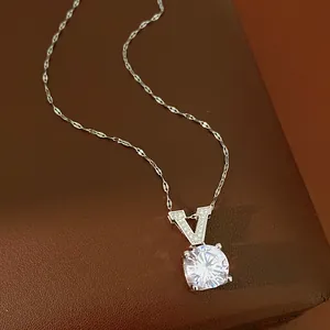 Close-up view of a sparkling zircon pendant with a V-shaped bail on a delicate silver chain