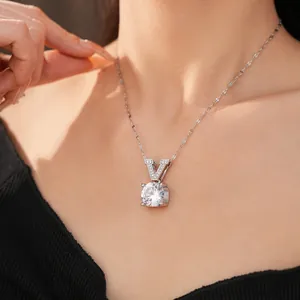 Close-up view of a silver necklace featuring a round zircon and a V-shaped pendant detail.