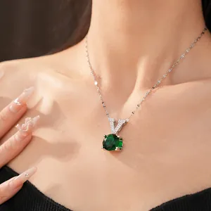 Detailed shot of a green round zircon pendant with a V-shaped silver bail on a model