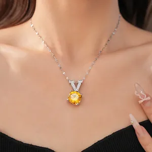 Detail shot of an elegant V-pendant necklace featuring a large round yellow zircon stone
