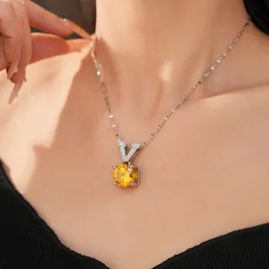 Detailed close-up of a silver necklace featuring a V-shaped pendant and yellow stone