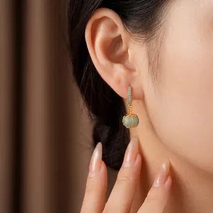 Elegante 14 Karat vergoldete Kürbis-Creolen mit türkisfarbenen Steinen am Modell
