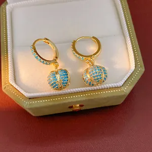Detailansicht von 14k vergoldeten Kürbis-Ohrringen mit blauen Zirkonia in einer Geschenkbox