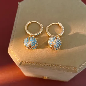 Exquisite 14k vergoldete Creolen mit blauen Zirkonia-Kürbis-Anhängern im Detail
