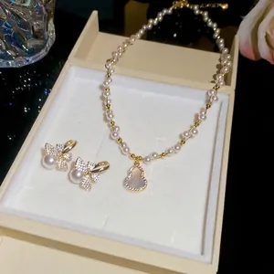 Elegant vintage pearl necklace and bow earring set with sparkling zircon accents