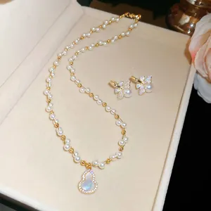 Close-up of elegant pearl jewelry set with gourd pendant and bow earrings in box