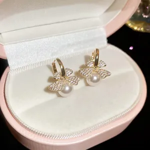 Macro view of French vintage bow earrings featuring zircon stones and pearls