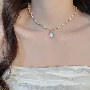 Close-up of a French vintage pearl necklace featuring a zircon hulu pendant on a model
