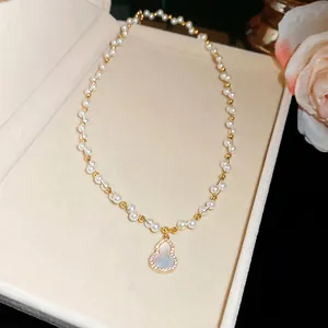 Close-up of elegant pearl necklace with zircon-encrusted gourd pendant in gift box