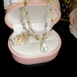 Detail view of French retro pearl necklace with gourd pendant and bow knot earrings