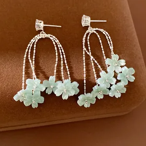 Primo piano di eleganti orecchini a nappa con fiori in resina e perni in zircone