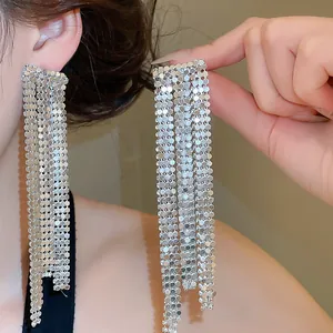 Close-up of silver mesh tassel earrings worn by a model for elegant evening looks.