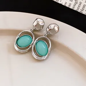 Detail view of French vintage silver drop earrings featuring mint green oval pendants