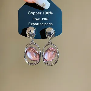 Close-up detail of French vintage silver needle earrings with pink oval acrylic pendants