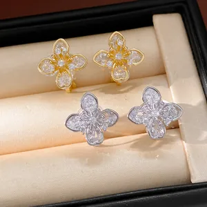 Close-up of zircon clover flower ear clips in a beige jewelry display box