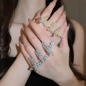 Detailansicht der glitzernden gold- und silbernen Zirkon-Weizenringe an den Händen des Models.