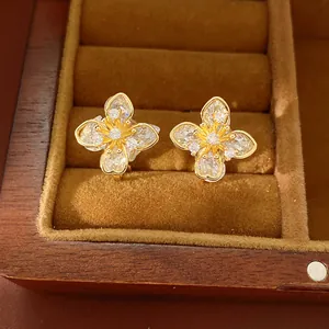 Detailed macro shot of elegant zircon flower clip-on earrings in a wooden jewelry box.
