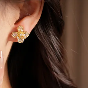 Close-up of zircon clover flower ear clip earrings with 18k gold plating