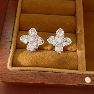 Detailed view of sparkling zircon clover flower clip-on earrings in jewelry box
