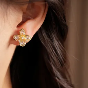 Detailed close-up of an elegant zircon flower ear clip worn on ear with real gold plating