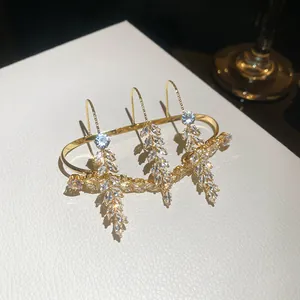 Nahaufnahme goldener Mehrfingerring mit Weizenähren-Design und Zirkonsteinen