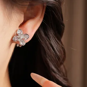 Close-up of sparkling zircon flower ear clip on ear showing delicate details