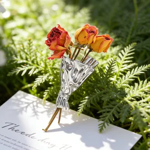 Detailansicht einer silbernen Bouquet-Brosche mit kleinen getrockneten Rosen