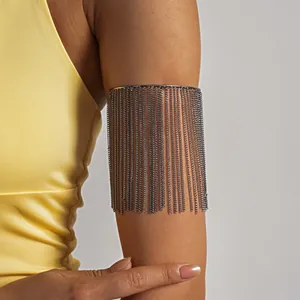 Detailweergave van een metalen kettingfranje armmanchet gedragen op de bovenarm