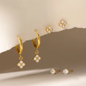 Detailed macro view of gold plated stainless steel clover earrings and zircon studs