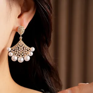 Elegant 18K gold plated fan-shaped earrings with pearls and cubic zirconia on model