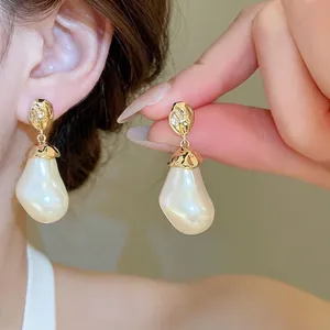 Französische Vintage-Perlenohrringe mit gehämmerten Goldsteckern, getragen am Modell