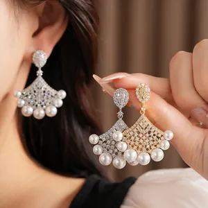 Detail of fan-shaped earrings featuring sparkling zircons and elegant white pearls