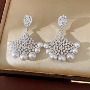 Elegant fan-shaped drop earrings with sparkling zircons and delicate white pearls.