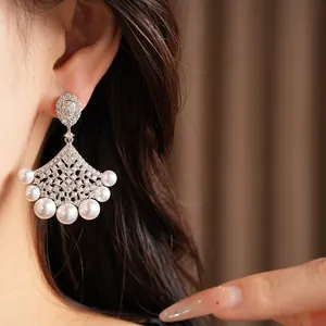 Detailed macro view of a fan-shaped earring featuring shimmering zircons and white pearls.