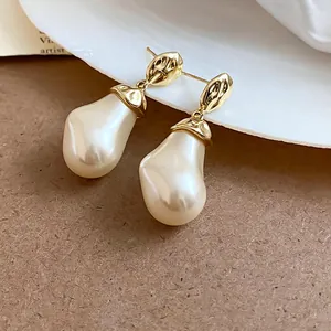 Detailaufnahme von französischen Retro-Ohrringen mit unregelmäßigen Perlen-Anhängern.