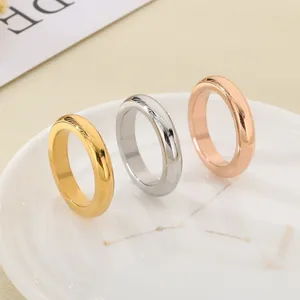 Primo piano di anelli minimalisti in acciaio al titanio color oro, argento e oro rosa